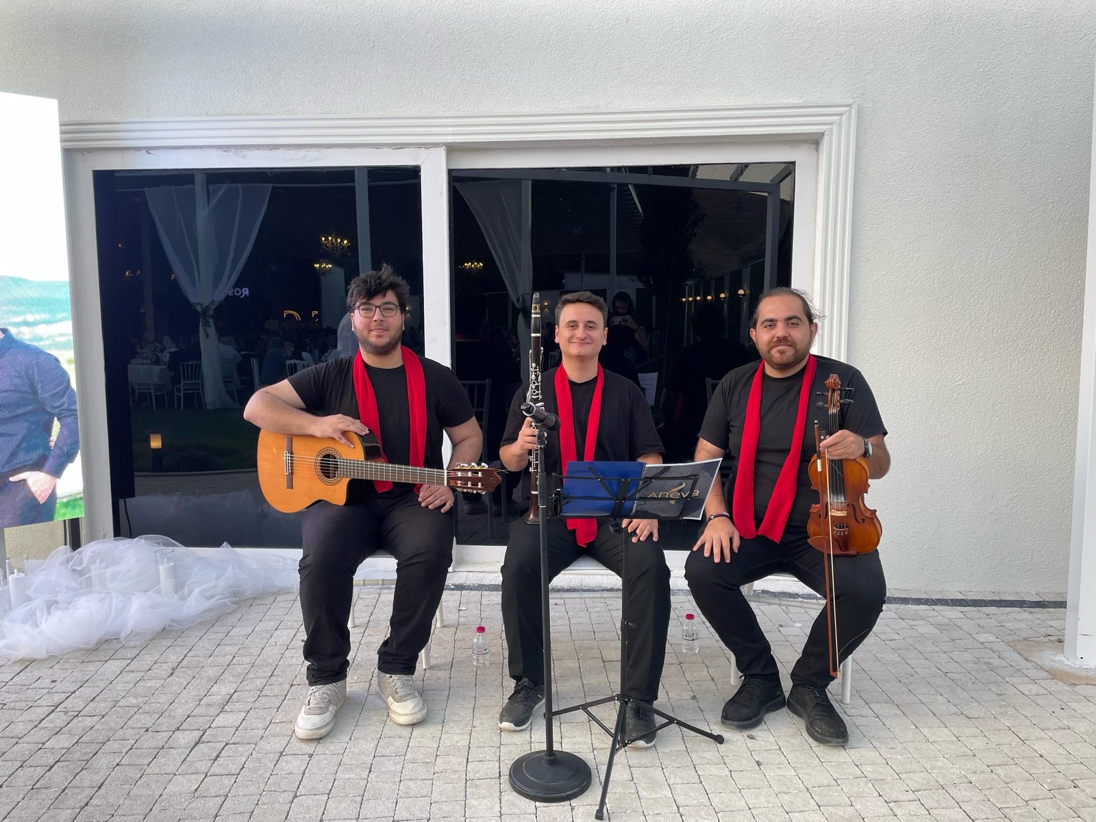 Aneva üçlüsü kırmızı fularlarıyla; gitar, klarnet ve kemanla düğün mekânında